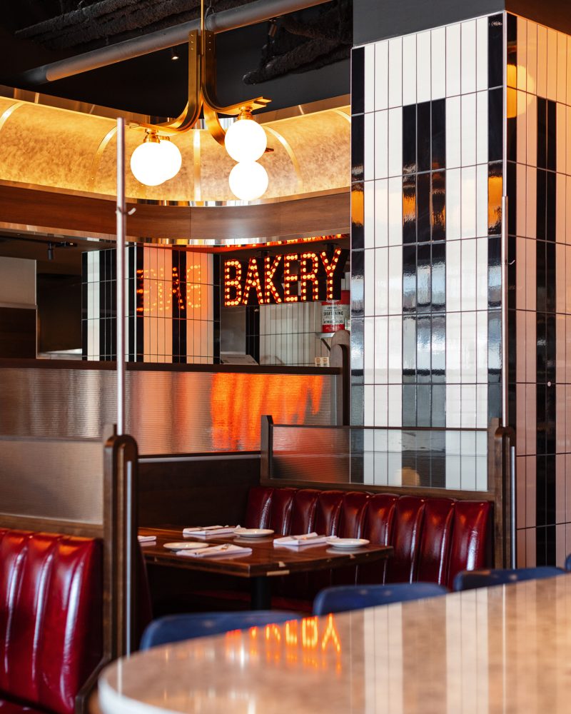Detail Cameron Mitchell Restaurant's Cap City Diner Cincinnati with booth seating and bakery sign in background